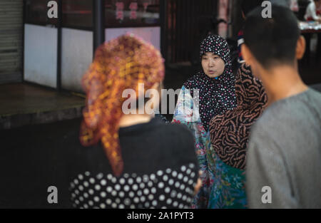 Xian, Chine - Août 2019 : les femmes musulmanes en conversation sur la rue dans le quartier musulman Banque D'Images