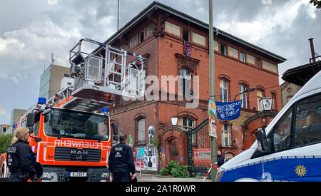 Berlin, Allemagne. 28 Sep, 2019. La police et les pompiers sont debout devant un bâtiment industriel vide dans le quartier de Friedrichshain. Des inconnus avec matériel d'escalade était entré dans le bâtiment et l'occupaient. La police est en contact avec le propriétaire afin de discuter des prochaines étapes. L'orateur a également n'a pas exclu l'évacuation du bâtiment. Crédit : Alexander Blum/dpa/Alamy Live News Banque D'Images