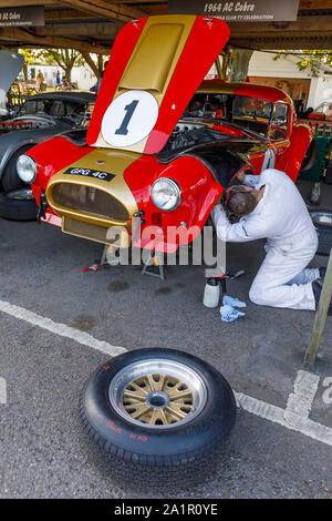 1964 AC Cobra 4.7 litre dans le paddock garage en cours de préparation par le mécanicien pendant 2019 Goodwood Revival, Sussex, UK. Célébration TT RAC participant. Banque D'Images