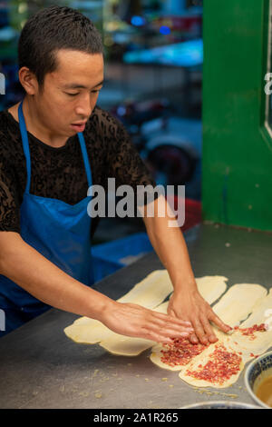 Xian, Chine - Août 2019 : faire de l'homme rempli de viande hachée de bœuf des pâtisseries dans une petite boulangerie locale sur la rue dans le quartier musulman de Xian, ville Banque D'Images