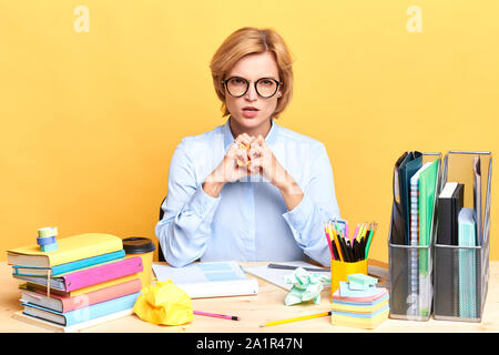 Frustrated woman déchirant ses documents, secrétaire d'être assez de beaucoup de travail, de frustration, de sentiments négatifs et d'émotion, fatigue, jaune isolé Banque D'Images