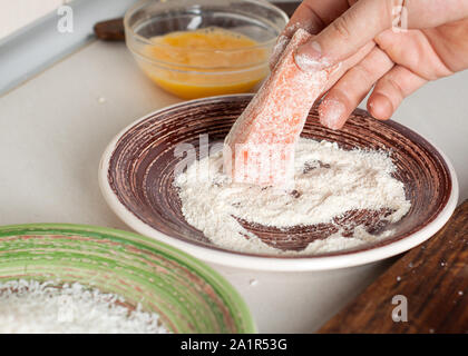 Saumon en croûte de noix de coco préparation. Trempage dans l'homme saumon chapelure panko Banque D'Images