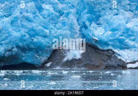 Un bloc de glace tombe et la langue verticale du glacier incliné du glacier du Nord-Ouest et frappe un rocher (deuxième de quatre photos). Banque D'Images