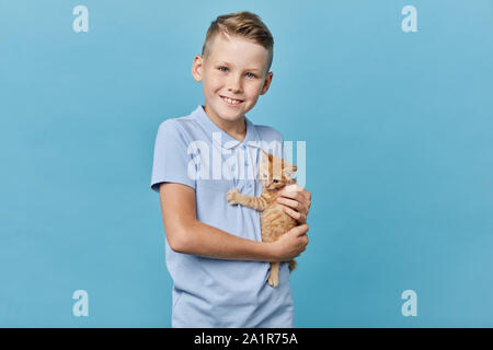 Petit garçon en bleu clair T-shirt prend soin de chaton. la photo en gros. enfance heureuse. close up portrait Banque D'Images