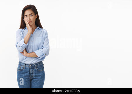 Les graves à la peine pour adultes intense brunette woman assister à l'événement ennuyeux sans intérêt, maigre sourire gêné, palm, regardez l'apathie de l'indifférence de l'appareil photo Banque D'Images