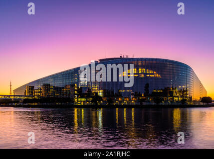 Crépuscule vue dans une lumière violette de l'est de la façade en verre du bâtiment Louise Weiss, siège du Parlement européen à Strasbourg, France. Banque D'Images