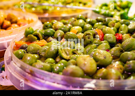 Des olives vertes marinées à l'ail et les épices dans le godet sur le marché espagnol Banque D'Images