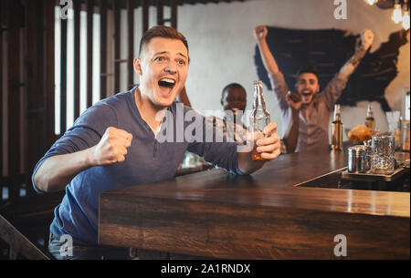 Regarder match football fan excité en bar, boire de la bière Banque D'Images