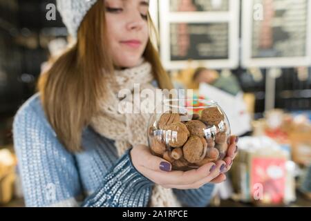 Portrait d'hiver belle jeune femme avec bol de noisettes et de noix. Jeune fille près de comptoir de café Banque D'Images