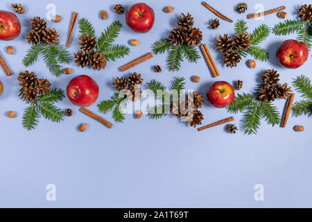 Composition de Noël. Les branches d'arbres, pins, pomme rouge, acorn et cannelle sur fond bleu pastel. L'hiver, Noël, nouvel an concept. Mise à plat, à Banque D'Images