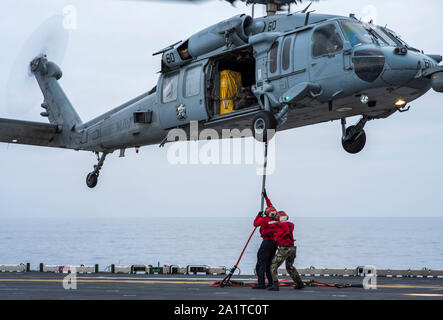 190926-N-SA412-0050 de l'OCÉAN PACIFIQUE (sept. 26, 2019) Les marins à bord du navire d'assaut amphibie USS Wasp LHD (1) accrocher une ligne de fret à un MH-60S Sea Hawk, affecté à la "matraques" de la mer de l'Escadron d'hélicoptères de combat (HSC), 21 au cours d'un ravitaillement vertical avec le ravitaillement de la flotte militaire commande de réapprovisionnement oiler USNS Henry J. Kaiser (T-AO 187). Le Wasp est actuellement à un passage de l'attache à Sasebo, au Japon Norfolk. (U.S. Photo par marine Spécialiste de la communication de masse 3 Classe Sean Galbreath) Banque D'Images