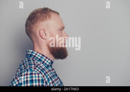 Vue côté profil portrait de nice calme bien entretenu d'esprit beau mec avec barbe portant chemise à carreaux sur fond gris pastel isolés Banque D'Images