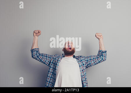 Dans l'homme extatique chemise à carreaux décontractée soulevées ouvrez palm hands up bouche grande ouverte se isolé sur fond gris clair jusqu'à tête en arrière Banque D'Images