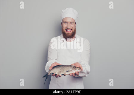 Portrait de il beau beau beau Gai gai optimiste positive guy boucher transport du poisson en tenant la main du bras de savoureux fruits de mer recette yummy Banque D'Images