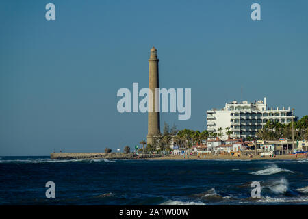 Maspalomas, Espagne - Jan 5, 2012 : le phare de Maspalomas est très clairement visible sur un ciel bleu clair. L'eau bleu avec têtes en mousse blanche. Banque D'Images