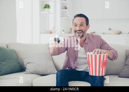 Brunet attrayant cheveux homme s'asseoir sur le confort canapé confortable canapé dans den Banque D'Images