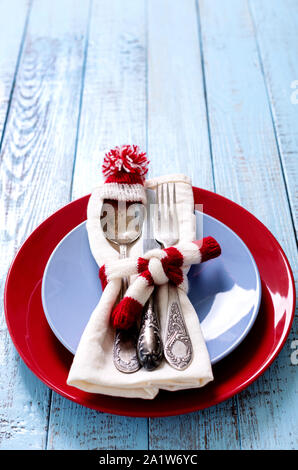 Réglage de la table de Noël avec des décorations de Noël sous la forme d'un bonnet et écharpe en tricot en blanc et rouge sur un vieux fond de bois avec l'exemplaire de l'espace. Banque D'Images