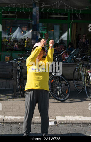 Sint Niklaas, Belgique, le 8 septembre 2019, Oriental woman with hat pratiqué Falun Dafa, soulève doucement ses bras en l'air Banque D'Images