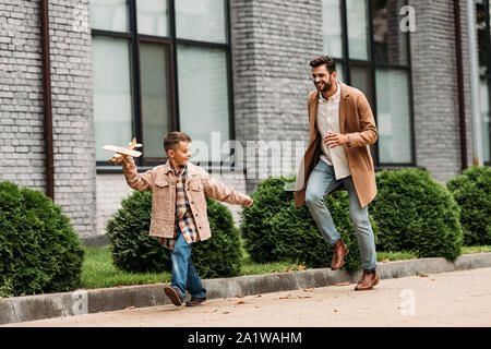 Sur toute la longueur de père en fils et robe avec toy avion fonctionnant sur street Banque D'Images