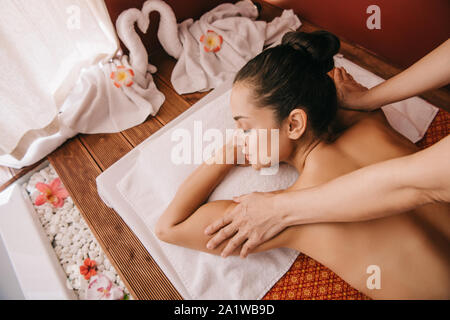 Portrait de ce masseur massage de l'épaule à la femme sur le tapis de massage Banque D'Images