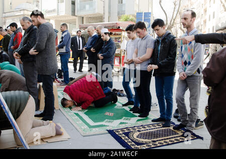 Istanbul, Turquie, mars 08,2019 : les hommes musulmans prier dans la rue en face de nombreuses mosquées à Istanbul le jour ensoleillé Banque D'Images