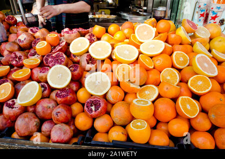 Tas de matières d'oranges et de grenades de la rue du marché, la préparation de produits frais juteux outdoor le jour ensoleillé, Close up full frame Banque D'Images