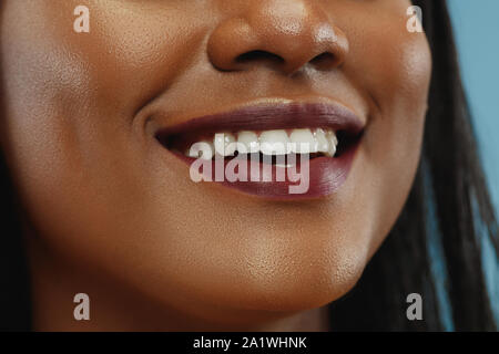 African-american woman's portrait. Beau modèle féminin en chemise blanche avec la peau bien entretenu. Concept d'émotions humaines, expression du visage, la beauté. Souriant, laughting. Les lèvres et les joues. Banque D'Images