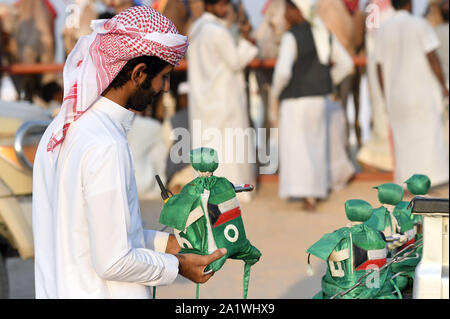 Al Ahmadi, le Koweït. 28 Sep, 2019. Un homme est titulaire d'un robot jockey d'être fixé sur le dos d'un chameau de course dans le gouvernorat d'Al Ahmadi, le Koweït, le 22 sept., 201928. Course de chameaux amour koweïtiens, qui est un événement sportif très populaire au Koweït. Credit : Ghazy Qaffaf/Xinhua/Alamy Live News Banque D'Images
