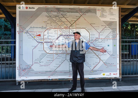 L'homme âgé se tient juste en face de Berlin BVG transport plan. Plan de S-Bahn, U-Bahn et de tramway à Berlin, Allemagne Banque D'Images