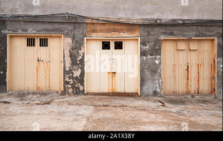 Trois portes jaune fermé dans une ligne dans la formation rocheuse mur, vieux port la façade de l'immeuble, vue avant Banque D'Images