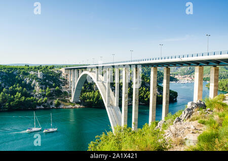 Petite ville de Skradin sur la rivière Krka, l'entrée du Parc National de la Krka. Deux yachts natation dans les villes sous le grand pont. Banque D'Images