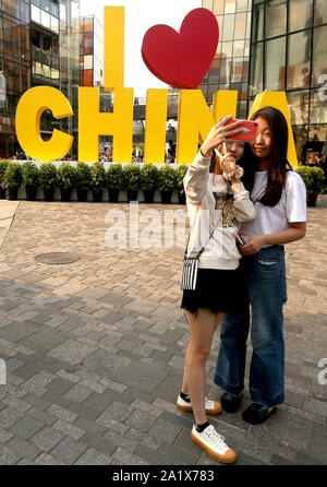 Beijing, Chine. Sep 29, 2019. Chinese prendre des photos devant un écran à venir célébrer le 70e anniversaire de la RPC, le dimanche, 29 Septembre, 2019. Capitale de la Chine a été décorée de fleurs, et des slogans patriotiques affiche communiste alors qu'il prépare le 1 octobre anniversaire. Photo par Stephen Shaver/UPI UPI : Crédit/Alamy Live News Banque D'Images