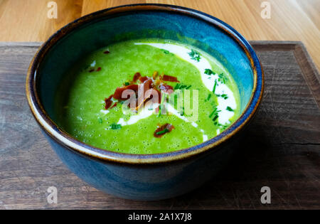 Stylo vert soupe avec du jambon et de la crème Banque D'Images