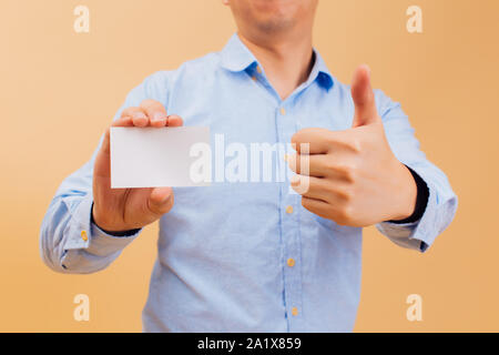 Close up of Businessman part montrant blanc vide carte d'affaires et giving Thumbs up en jaune vif. Nom carte vierge pour ajouter du texte Banque D'Images