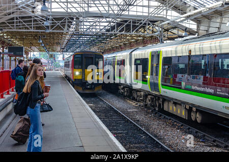 Le train en arrivant à Crewe (Cheshire, Angleterre) gare et banlieusards attendent sur la plate-forme numéro 3.