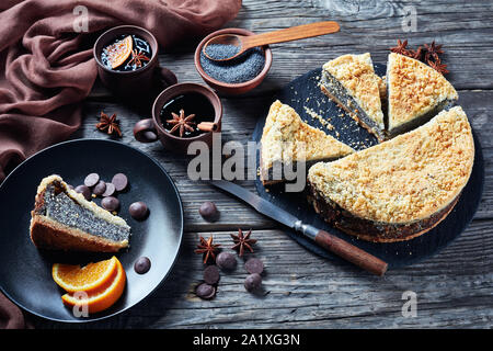 Graines de pavot délicieux gâteau au fromage Crumble servi avec des tranches d'orange et café sur une table en bois rustique, vue horizontale d'en haut Banque D'Images