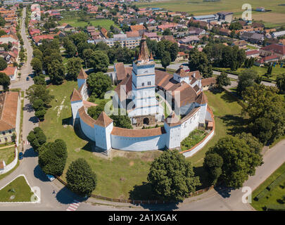 Vue aérienne de l'église fortifiée entourée de puissants murs épais en Transylvanie, surplombant le village dans une belle journée d'été. Roumanie Banque D'Images