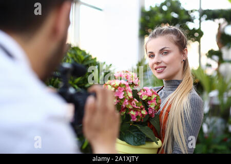 Blogger femme fleur rose d'enregistrement sur l'appareil photo Banque D'Images