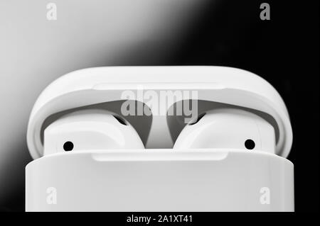 Blanc sans fil d'écouteurs ou de casques en plastique ou une boîte de rangement et de charge sur fond noir et blanc. Close up. Banque D'Images