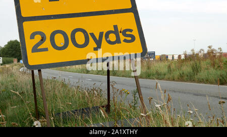 200 mètres de routes warning sign on UK autoroute à soirée avec le trafic passant Banque D'Images