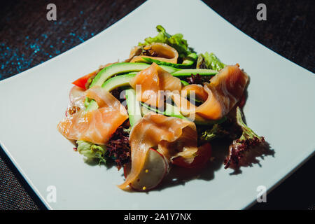 Salade de saumon à l'avocat, radis, Lola Rossa laitue, tomate. Banque D'Images