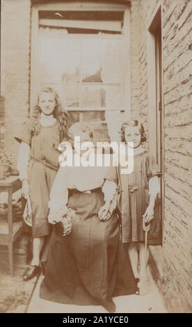 Vintage Début xxe siècle Carte postale photographique montrant une mère et ses deux filles. Banque D'Images