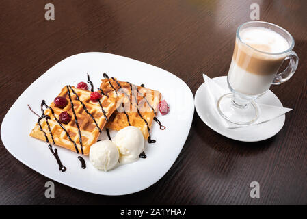 Des gaufres avec du café latte viennois, sur une table en bois. Banque D'Images