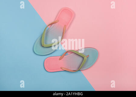 Style flip-flops sur rose et bleu pastel arrière-plan, Vue de dessus. Le minimalisme d'été concept avec copie espace. Banque D'Images