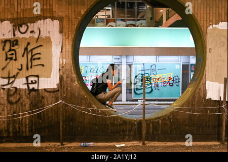 Hong Kong, Hong Kong. Sep 29, 2019. Une fille est assise sous un passage supérieur au cours d'un meeting de protestation qui ont tourné à la violence à Hong Kong le 29 septembre 2019. Photo de Thomas Maresca/UPI UPI : Crédit/Alamy Live News Banque D'Images