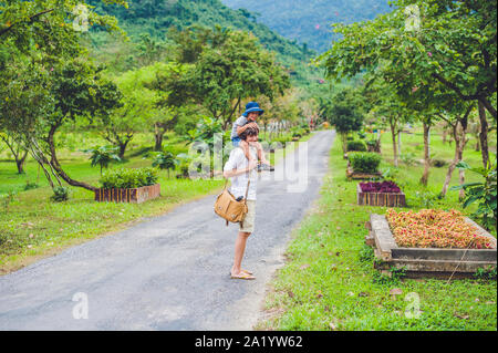 vue arrière de père et fils marchant sur un paysage route Banque D'Images
