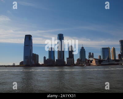 La ville de Jersey City, NJ le long de la rivière Hudson avec Ellis Island . Le front s'appelle maintenant la Côte d'or en raison de travaux de réaménagement. Banque D'Images