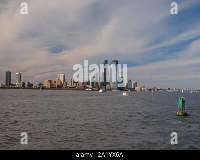 La ville de Jersey City, NJ le long de la rivière Hudson avec Ellis Island . Le front s'appelle maintenant la Côte d'or en raison de travaux de réaménagement. Banque D'Images