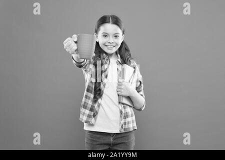 La littérature pour enfants. Aime passer du temps à la maison. Cacao chaud et bon livre idéal pour soirée agréable. Lecture bucket list. Dépenser temps agréable avec livre préféré. Fille tenir une tasse de thé et d'adresses. Banque D'Images