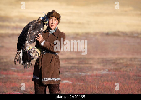 Kazakh traditionnel eagle chasseresse de flatter son golden eagle qui est utilisé pour chasser pour fox et fourrure de lapin. Ulgii, l'ouest de la Mongolie. Banque D'Images